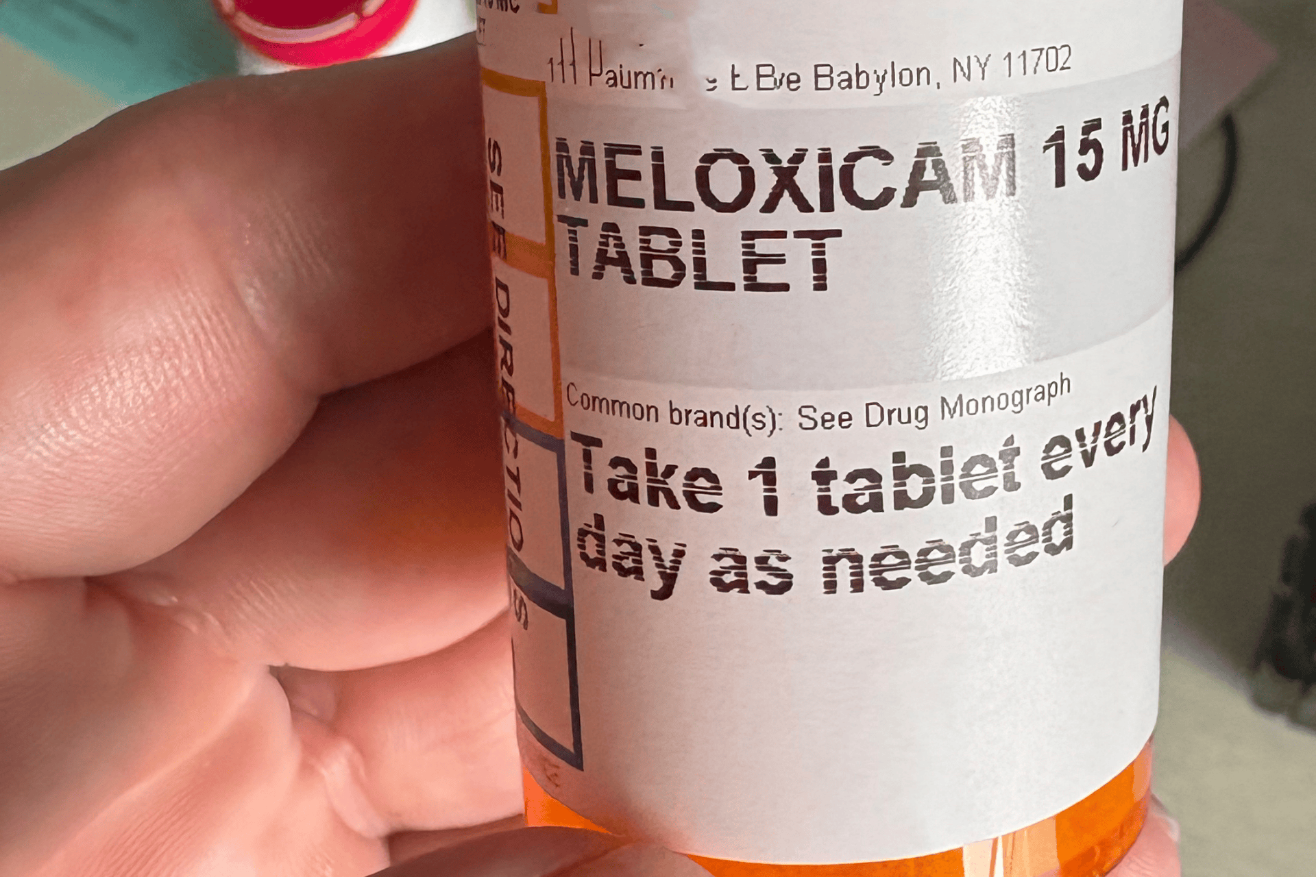 A close-up of a prescription bottle labeled Meloxicam 15 mg held in someone’s hand.