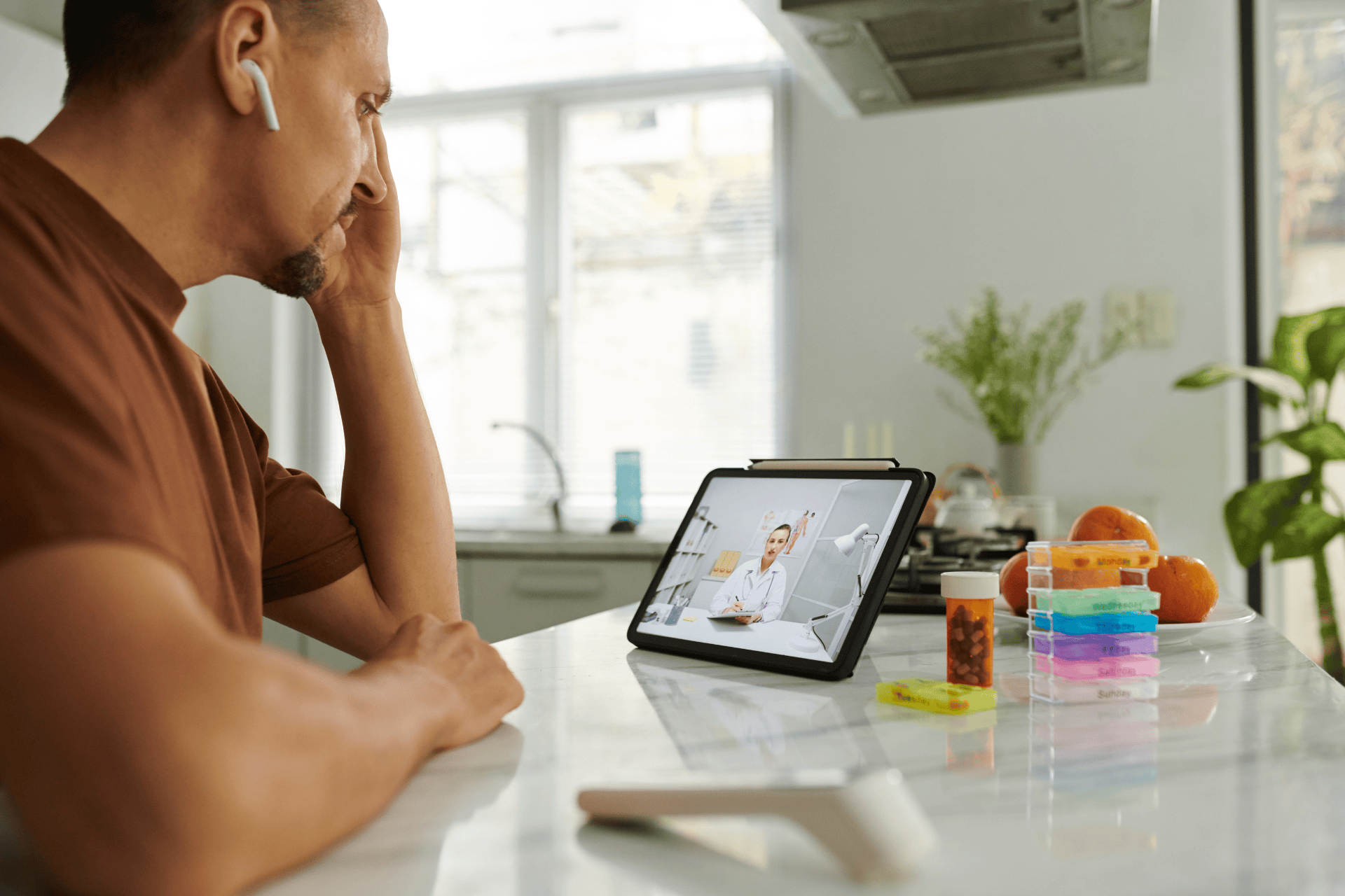 A Man having an online video consultation with a doctor using a tablet at home.