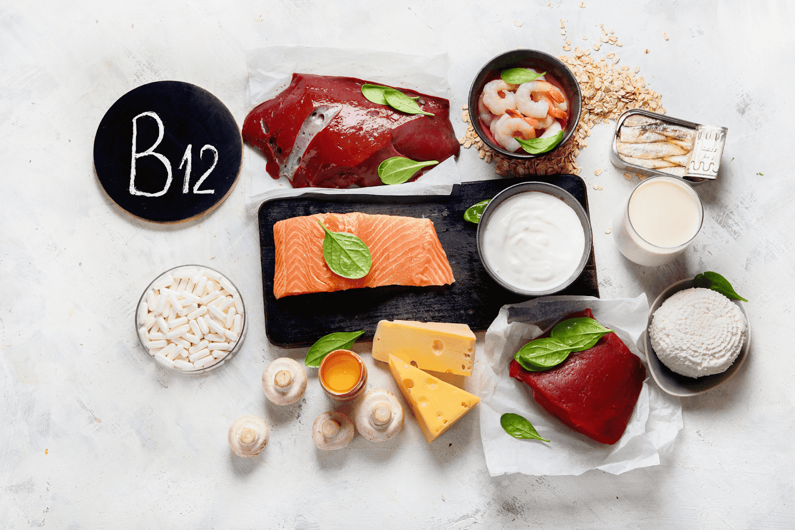 Assortment of vitamin B12-rich foods, including salmon, liver, shrimp, cheese, eggs, yogurt, and supplements.