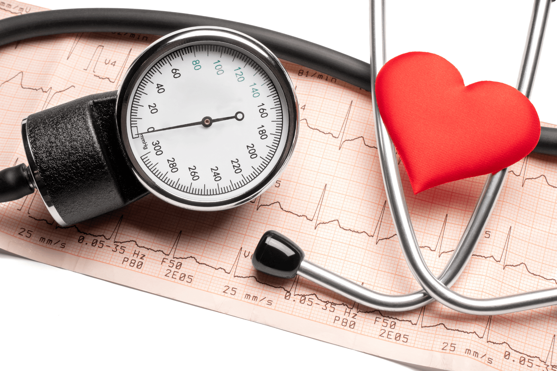 Blood pressure gauge and stethoscope placed on an EKG printout with a red heart.