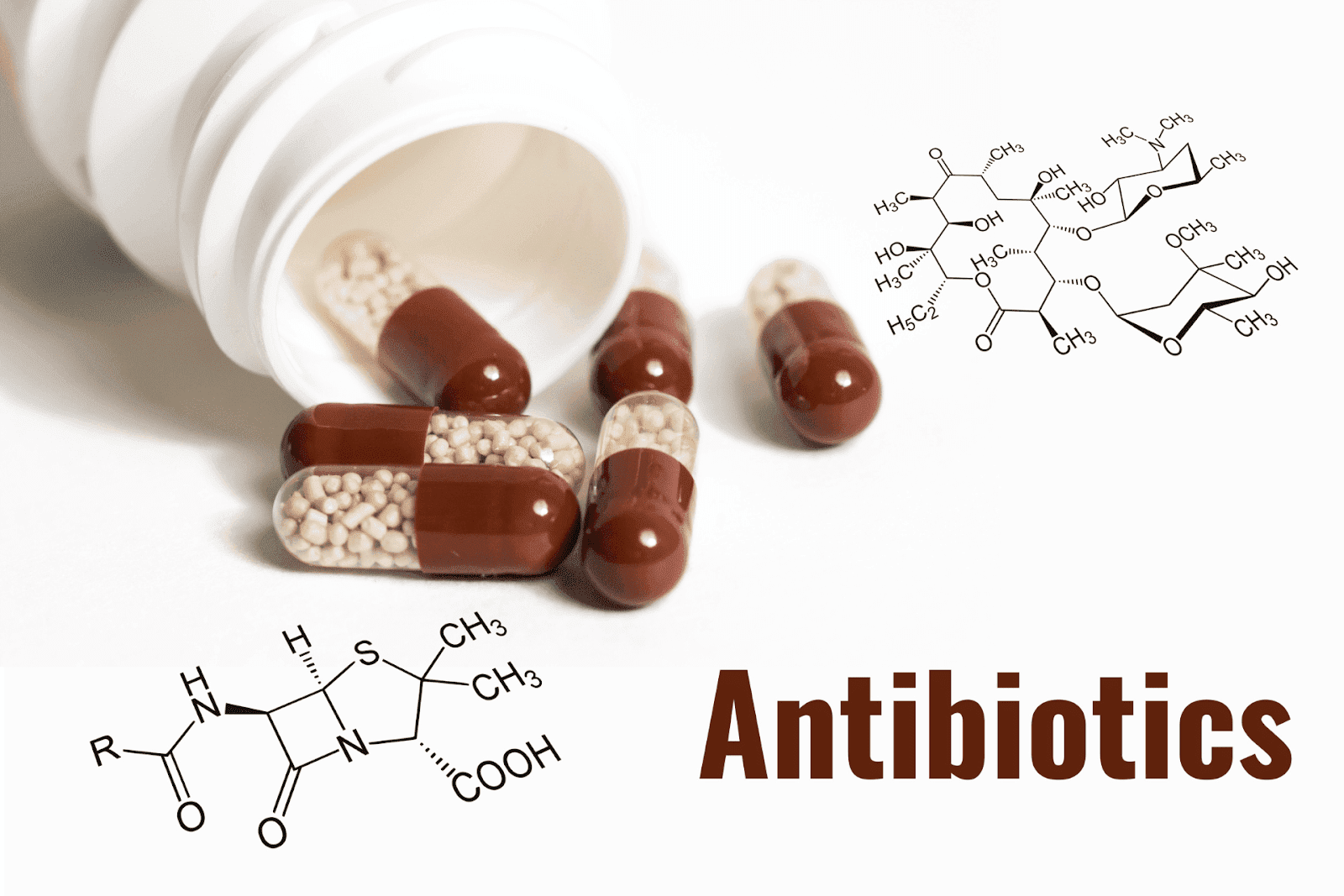 Capsules spilled from a pill bottle with “Antibiotics” text and chemical structures.