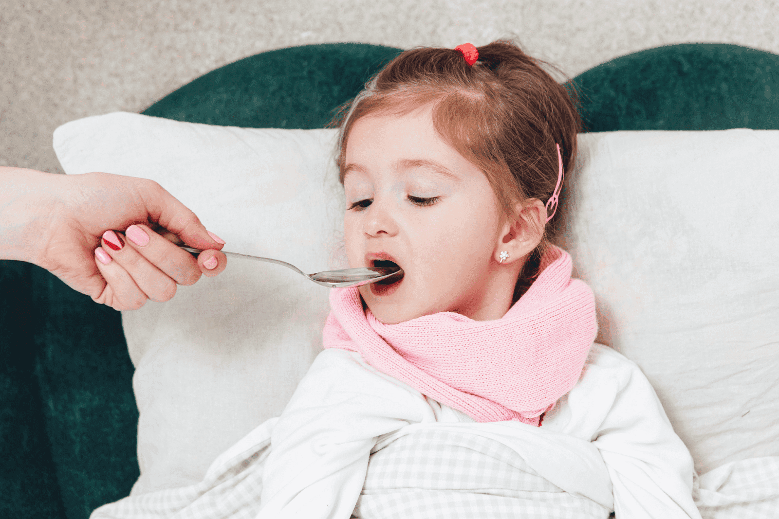 Child being given medicine with a spoon