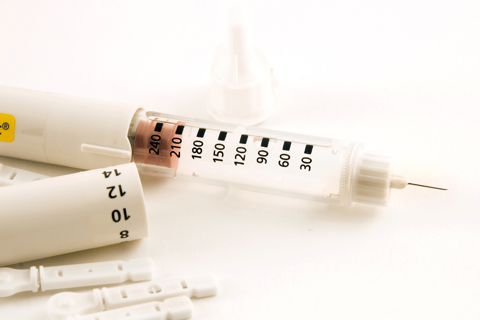 Close-up of a white insulin syringe with measurement markings and needle.