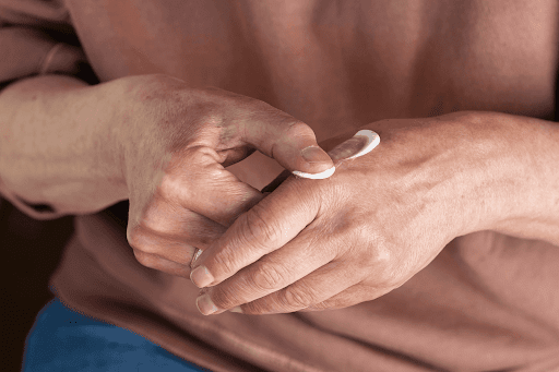 Close-up of hands applying cream to the back of one hand