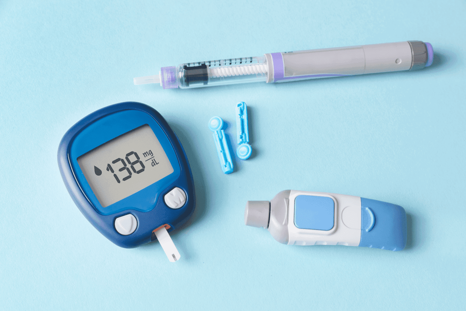 Diabetes management tools, including a glucose meter showing 138 mg/dL, an insulin pen, and lancets on a blue background.
