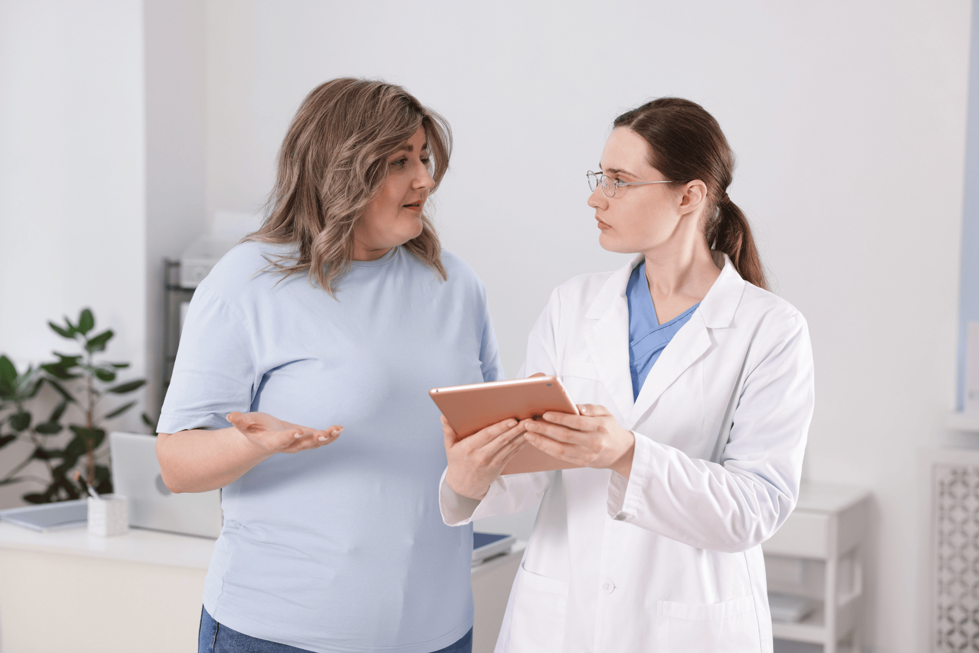 Doctor discussing results with a patient holding a tablet.