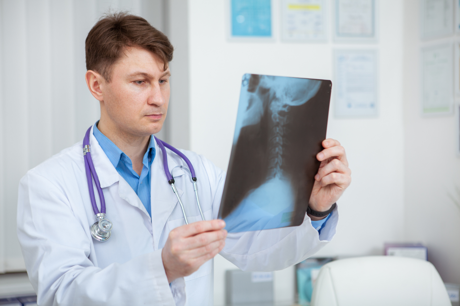 Doctor examining a cervical spine X-ray image in a medical office