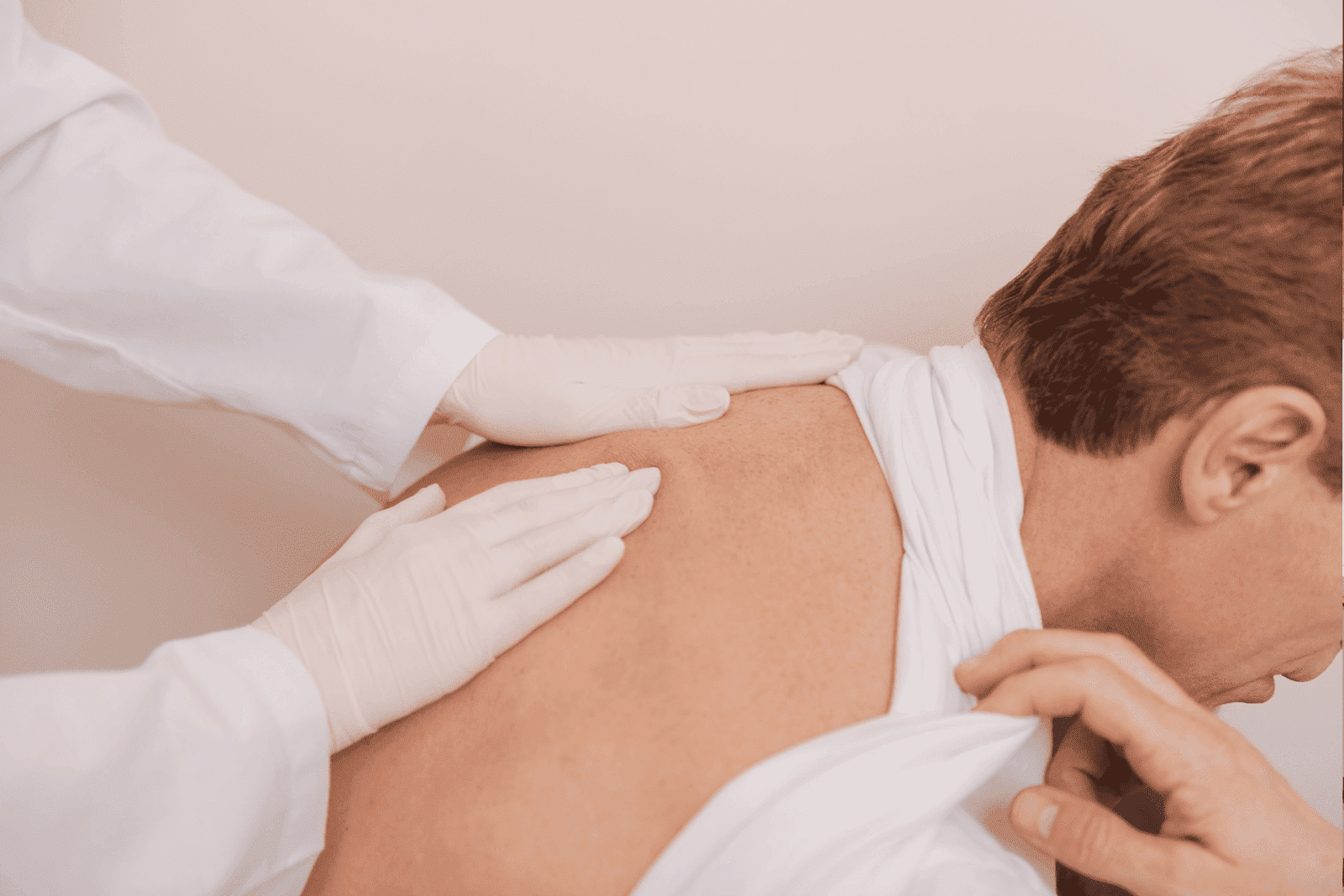 Doctor examining a patient's back using his hands