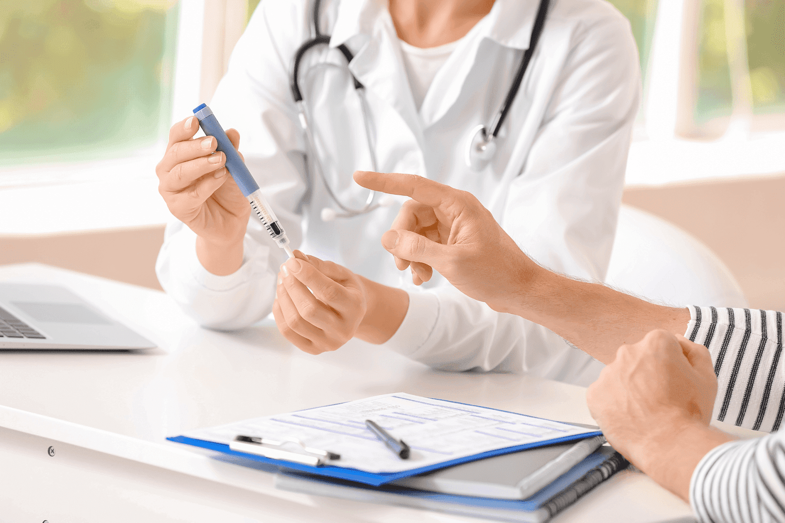 Doctor explaining how to use an insulin pen to a patient during a consultation