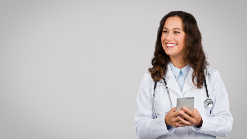 Doctor smiling and holding phone
