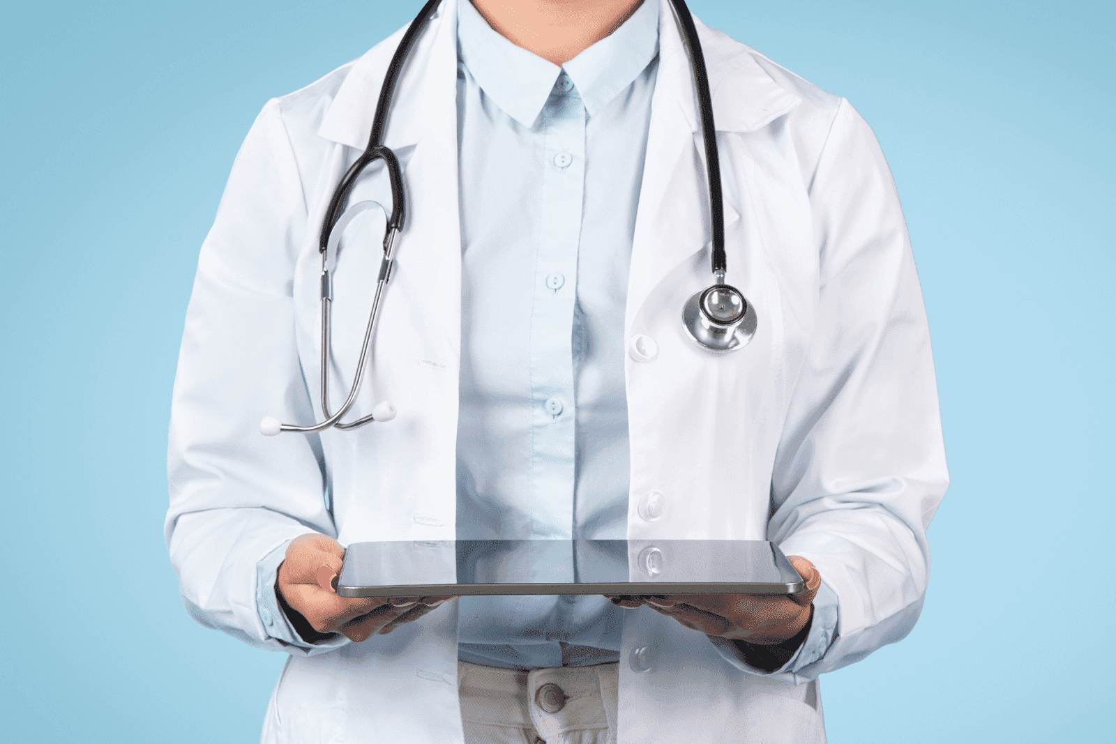 Doctor in a white coat holding a tablet.