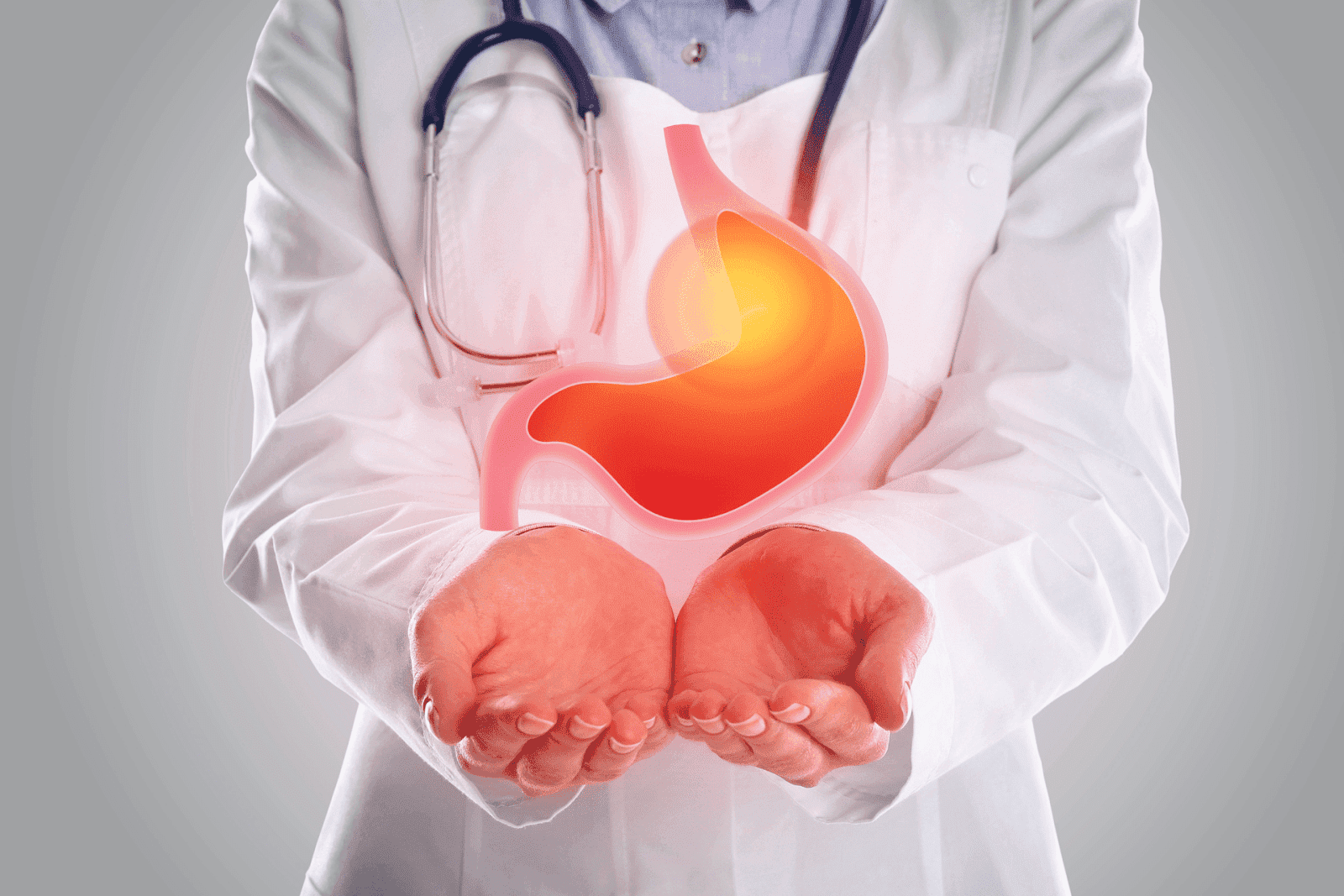Doctor in a white coat holding an illustration of a glowing stomachDoctor holding a digital illustration of a stomach with a highlighted area.