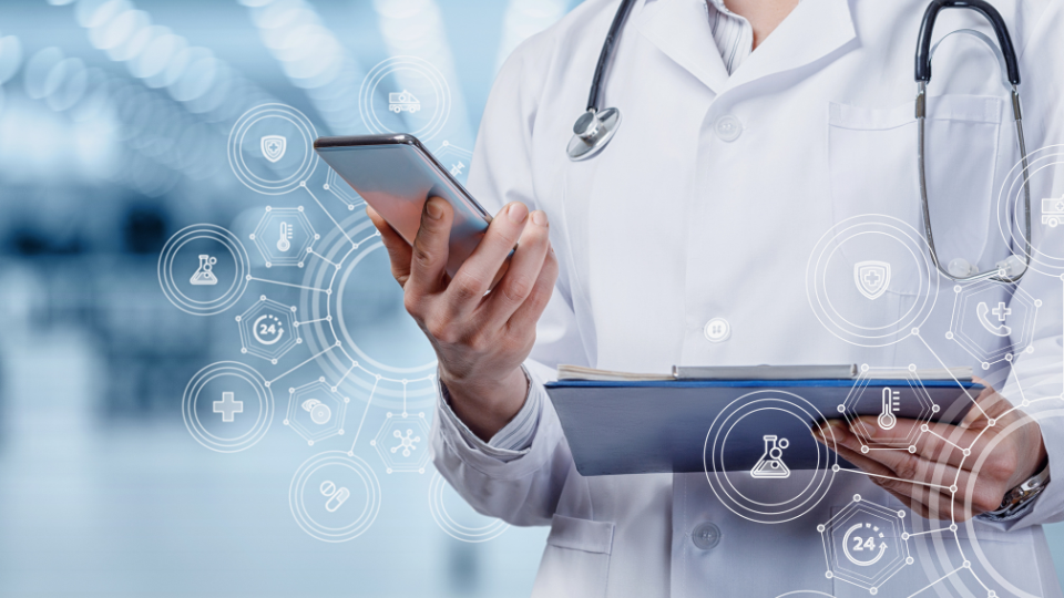 Doctor holding phone up with right hand and holding clipboard with left hand.