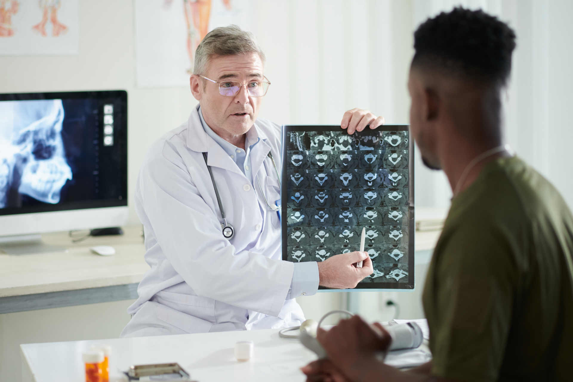 Doctor showing a patient a spine scan image during a medical consultation