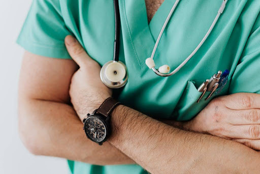 Doctor with stethoscope folding arms.