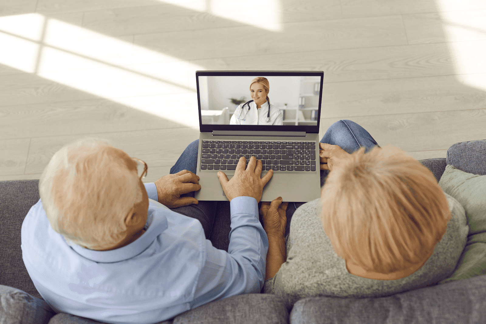 Elderly couple having an online consultation with a doctor on a laptop.