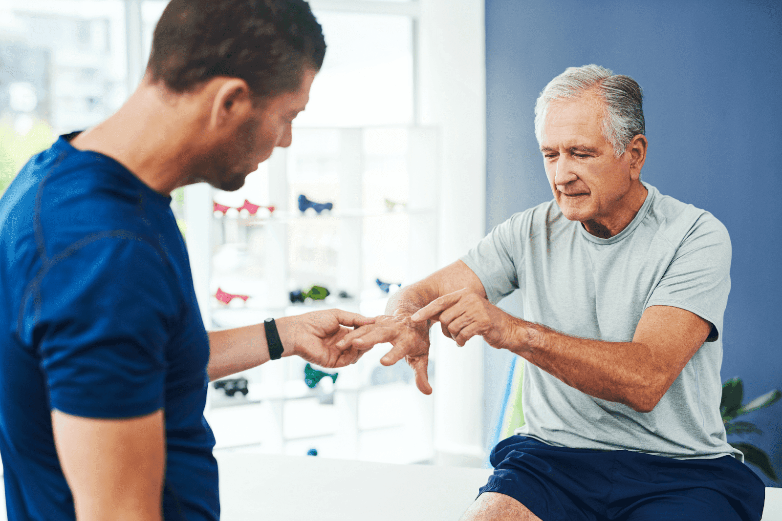 Elderly man pointing to finger pain during consultation