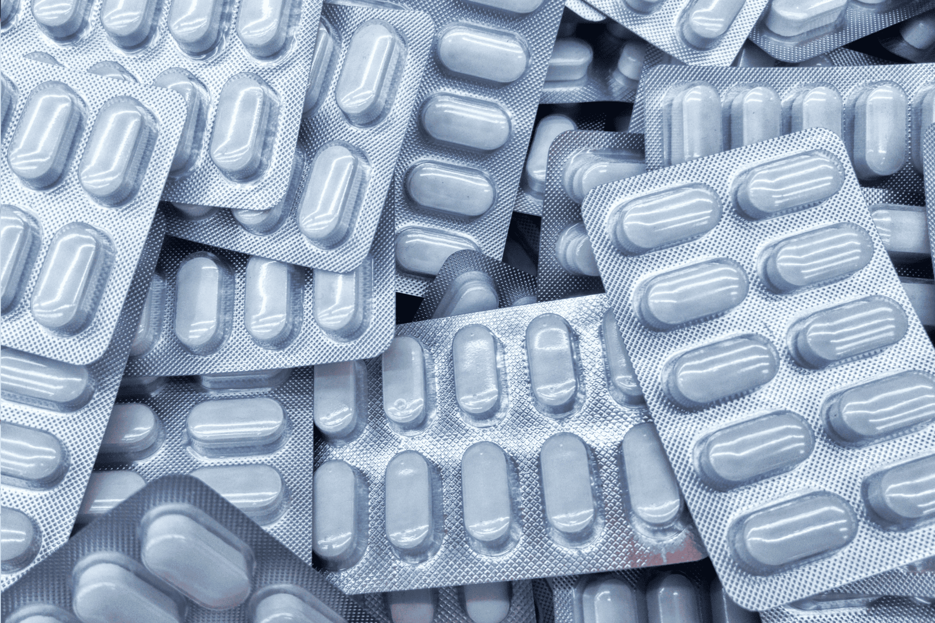Close-up of multiple blister packs filled with white tablets.