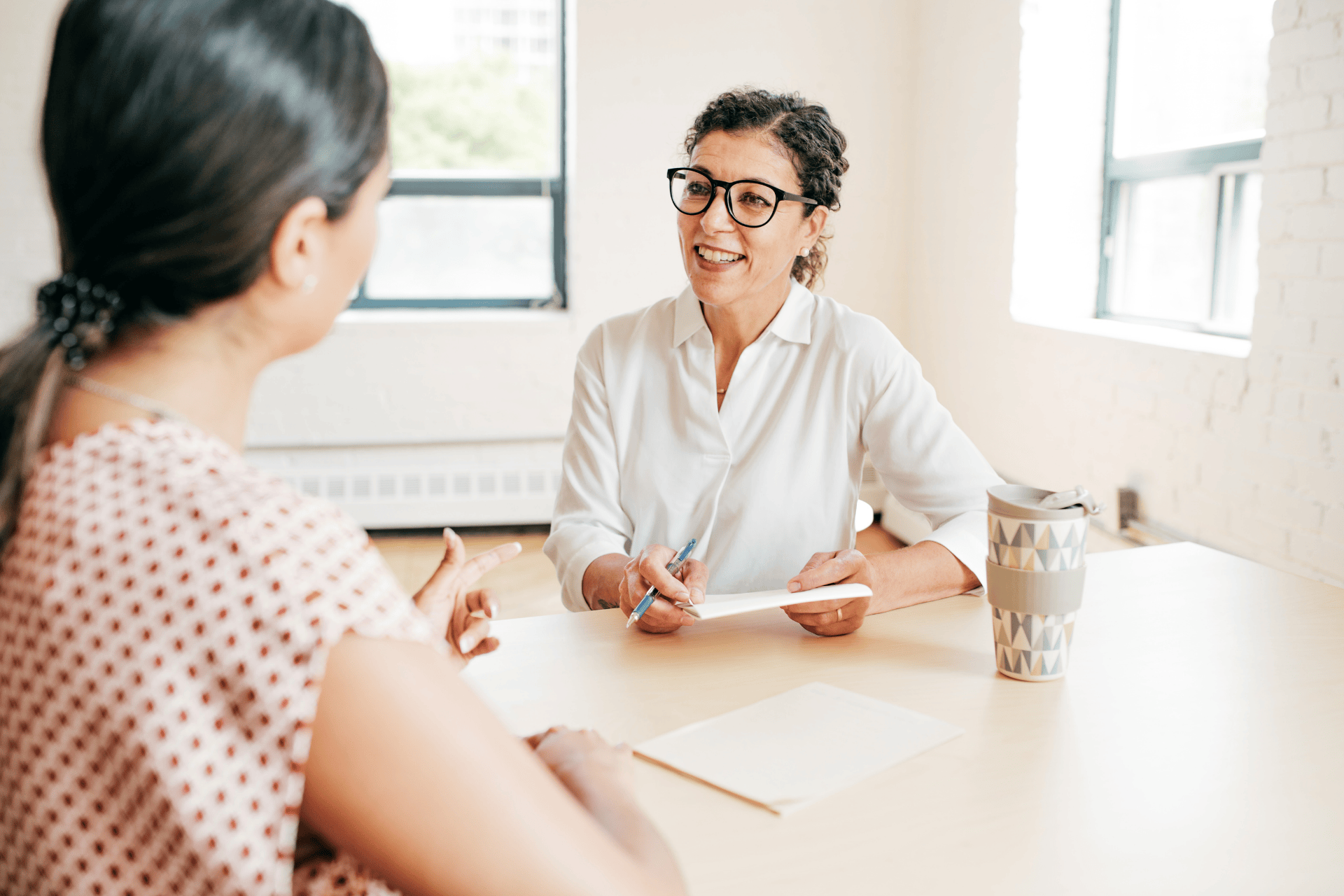 Smiling therapist talking with a client during a counseling session.