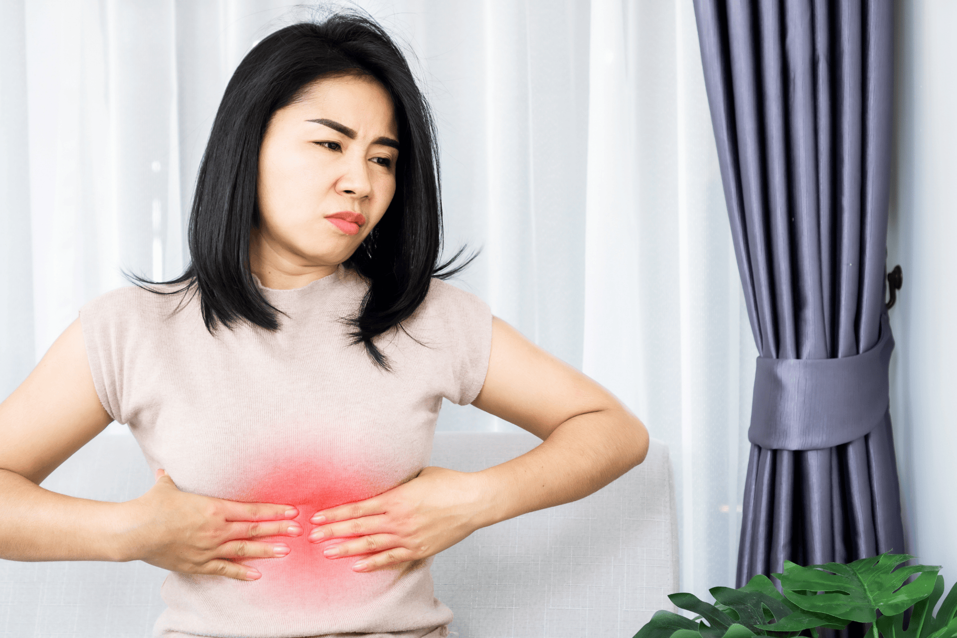 Woman clutching her chest in discomfort with a red highlight indicating pain.