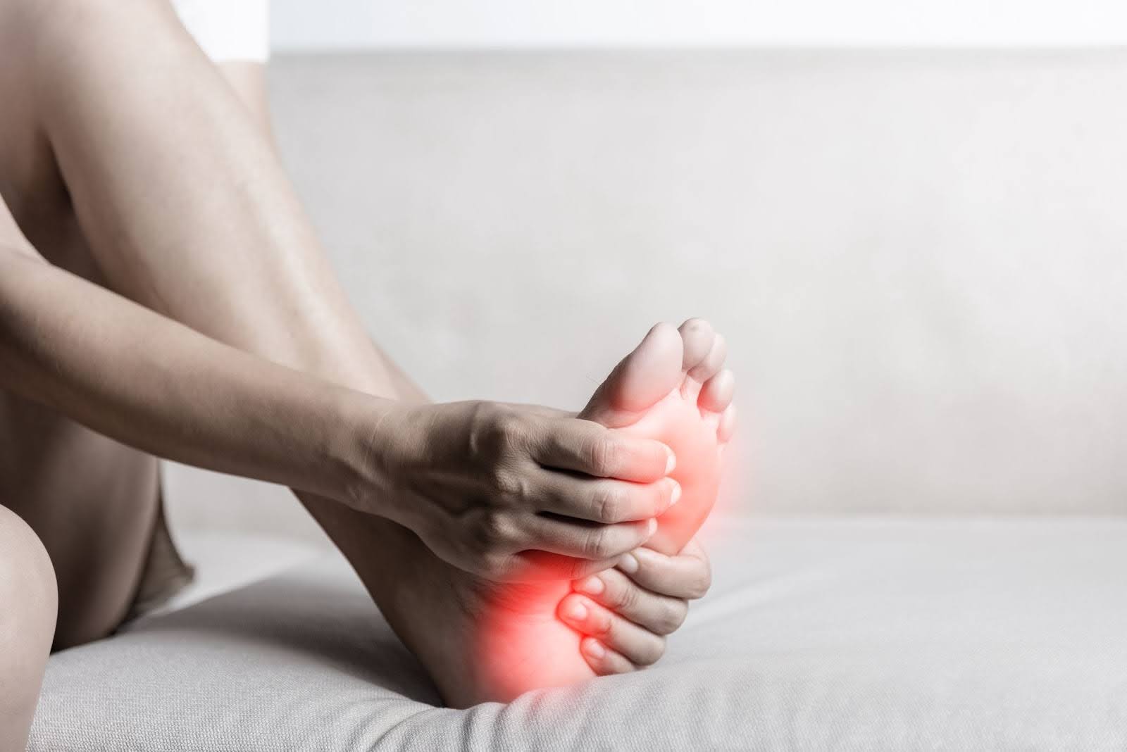 A woman holding her aching foot