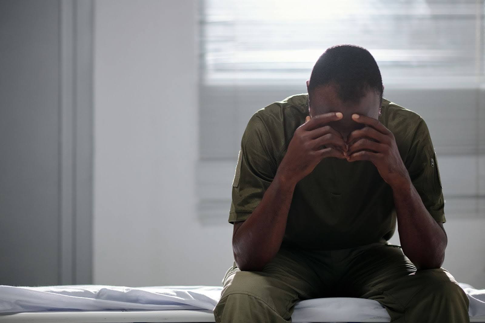 Man feeling depressed while sitting on a hospital bed