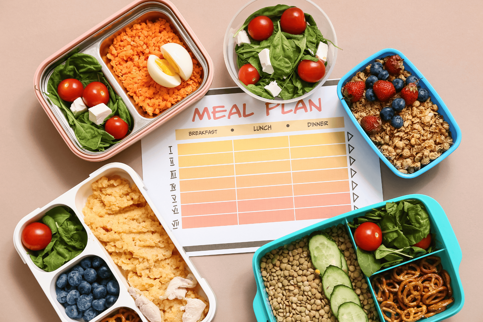 Healthy meal containers and a blank meal plan sheet on a table