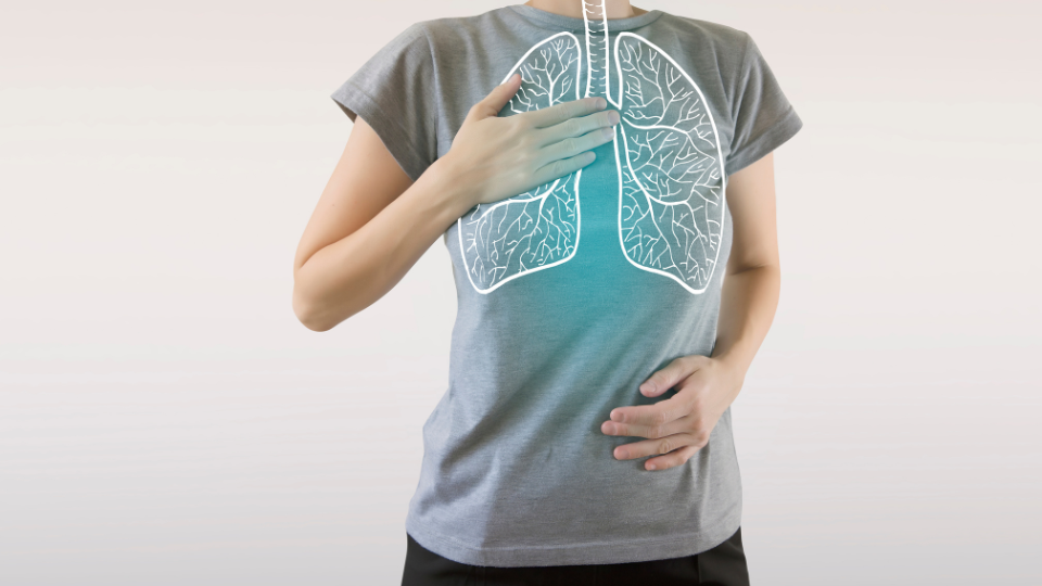Woman with hand on chest with illustration of lungs shown over her shirt