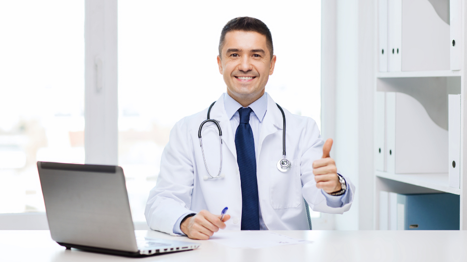 Male doctor smiling and giving a thumbs up