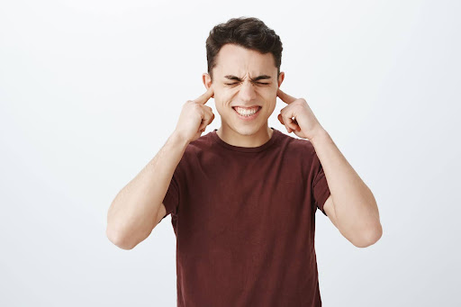 Man pressing his ears