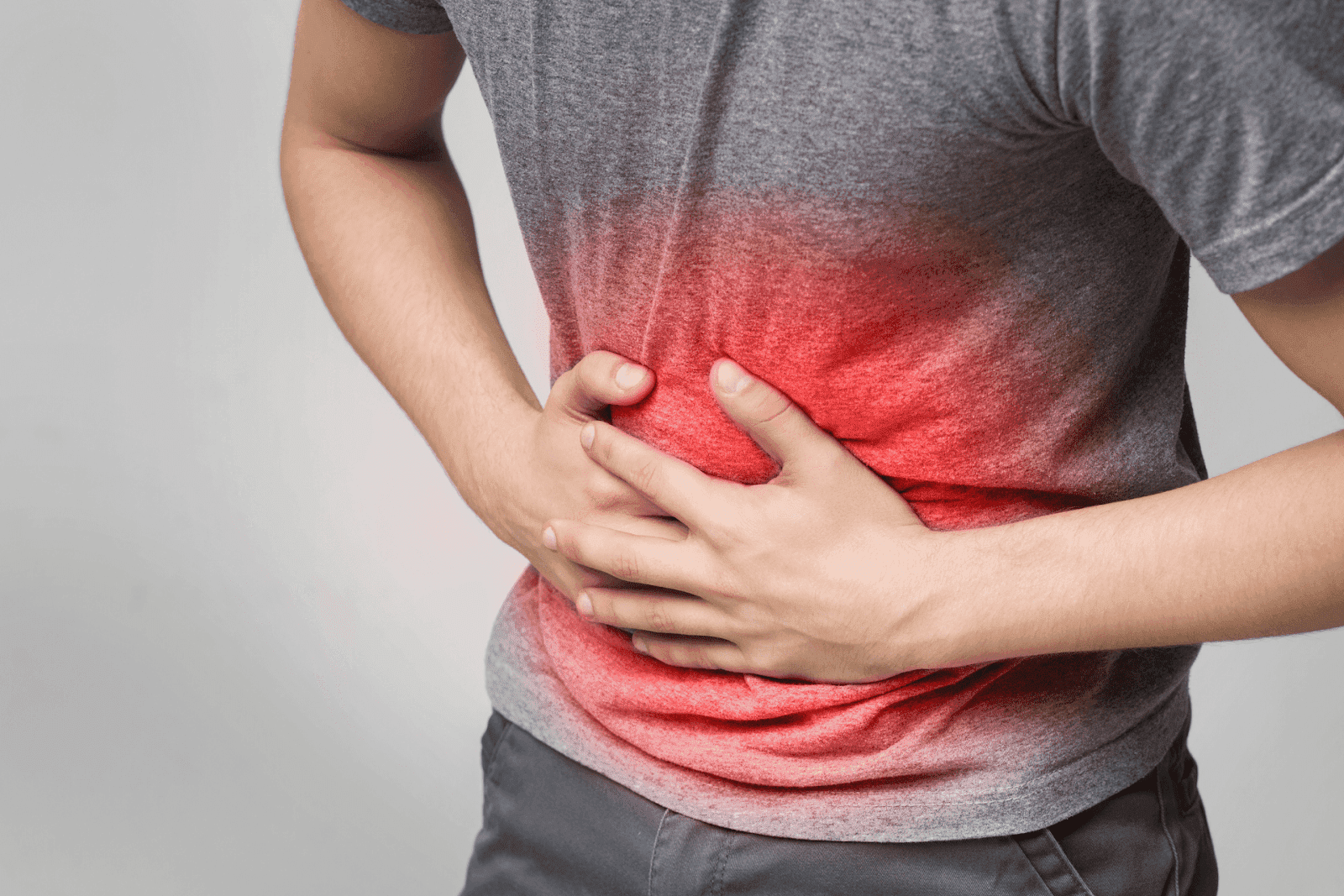Man holding his stomach with red highlight indicating pain.