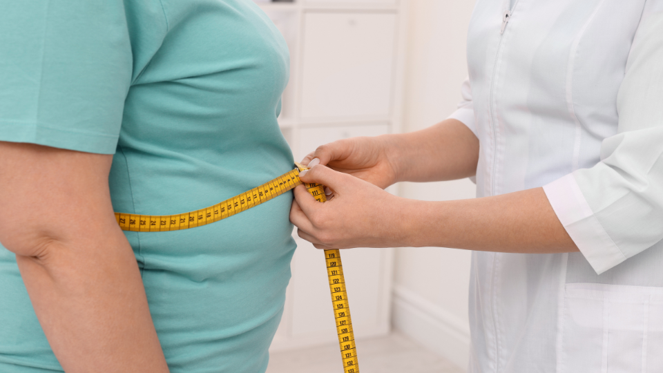 Doctor measuring patients midsection