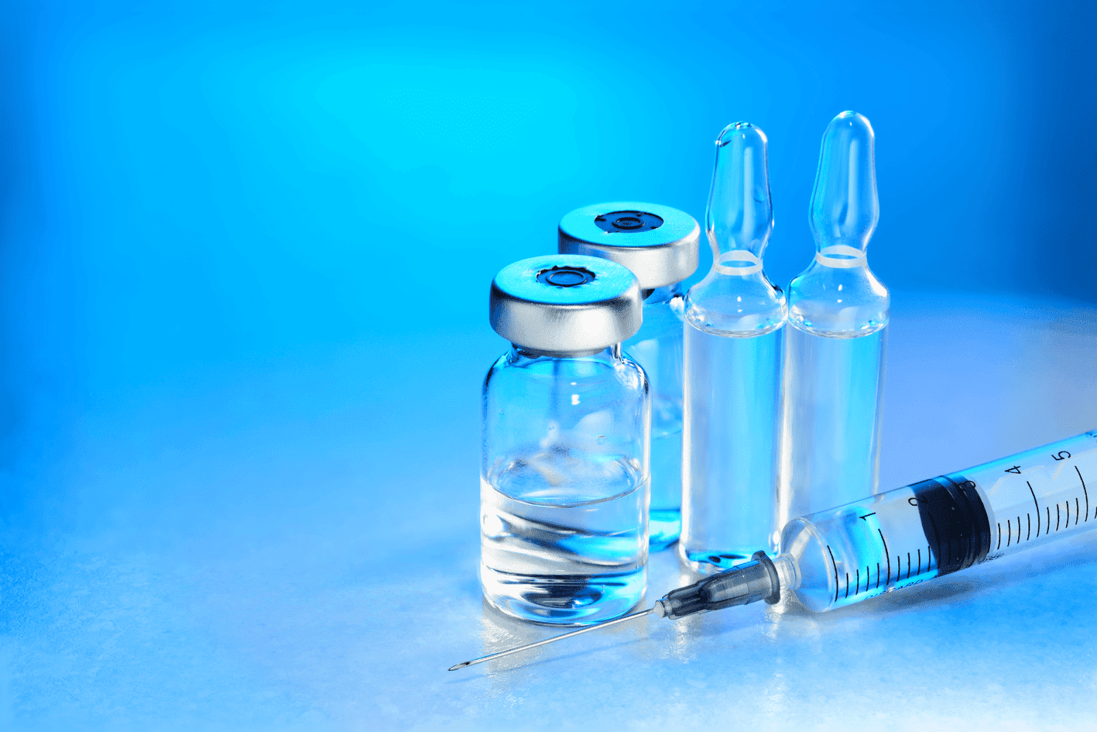 Medical vials and ampoules with a syringe on a blue background