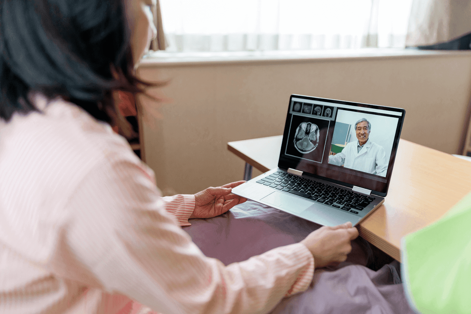 Patient having an online consultation with a doctor reviewing brain scan images.
