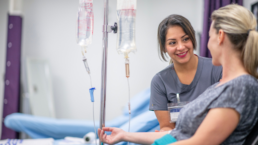 Patient recieving IV fluids speaking with nurse