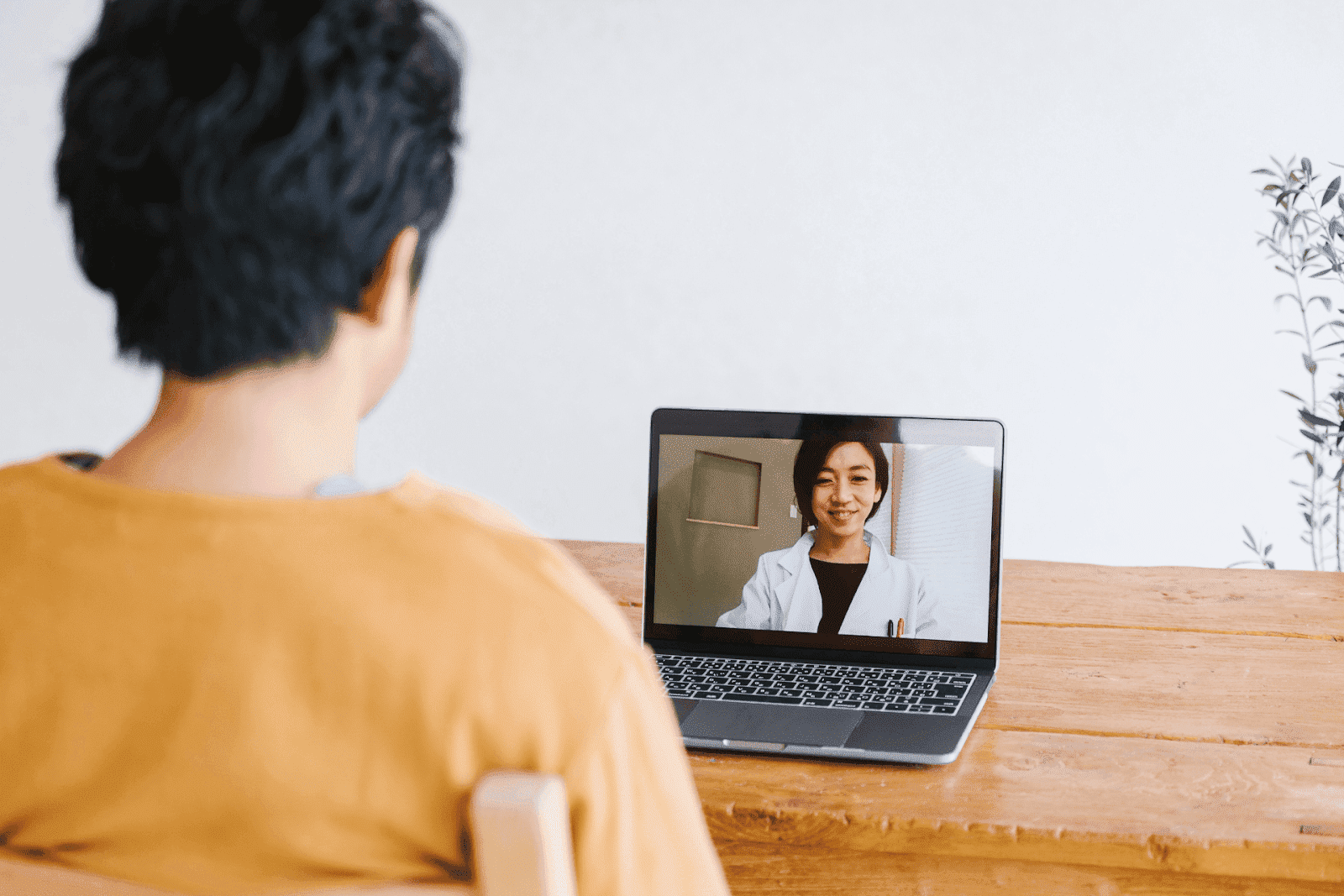 Person having an online video consultation with a doctor on a laptop.