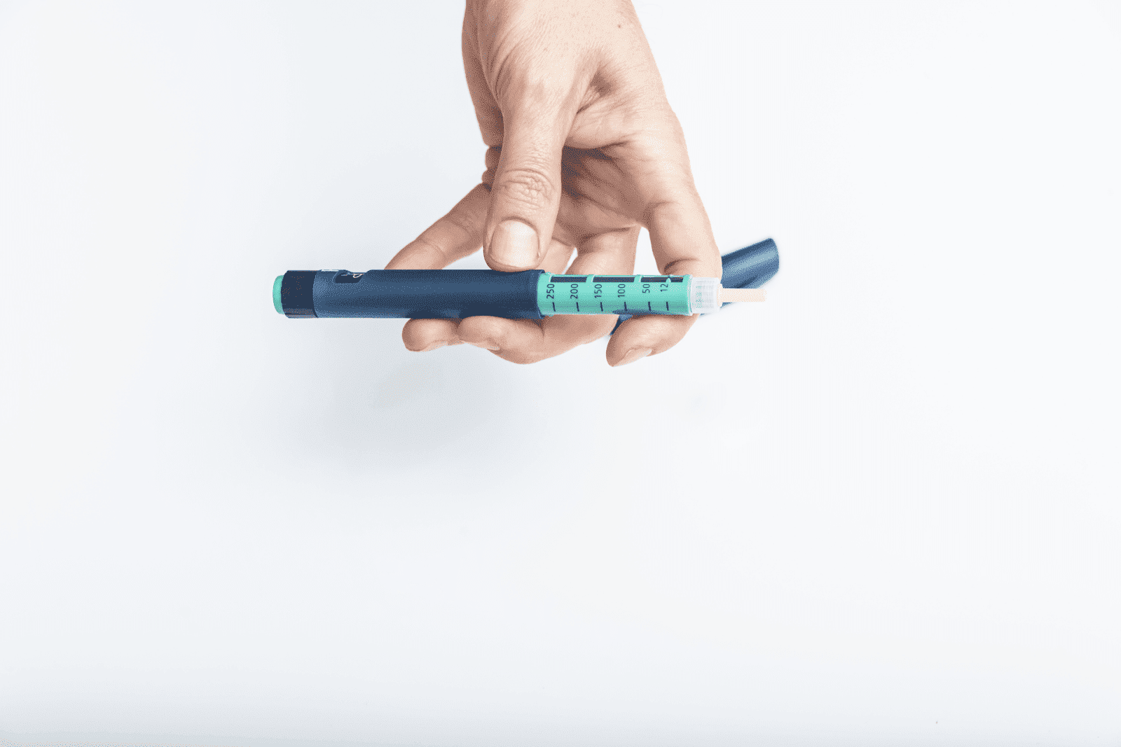 Person holding a blue insulin pen device