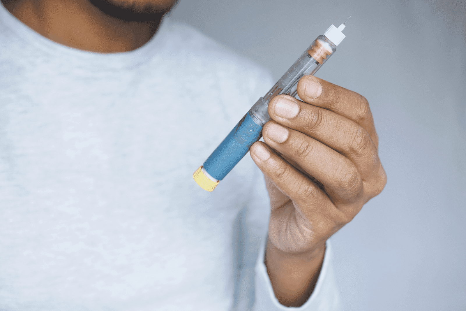 Person holding a blue insulin pen