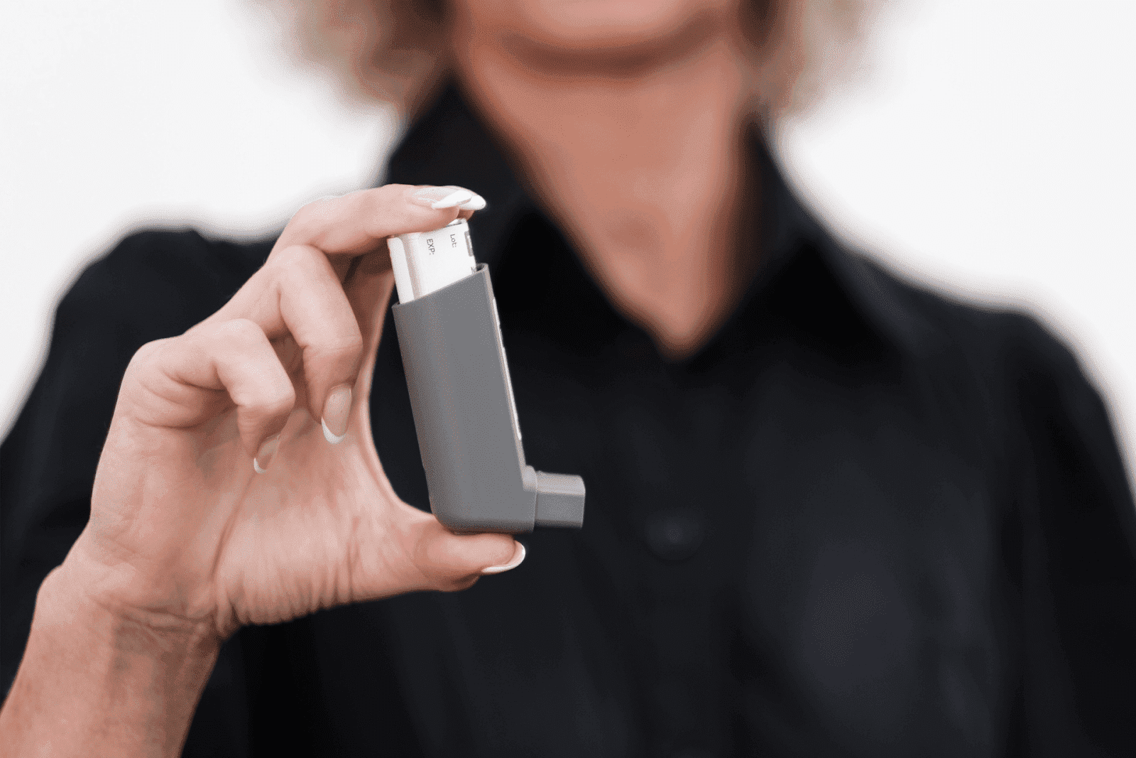 Person holding a handheld asthma inhaler