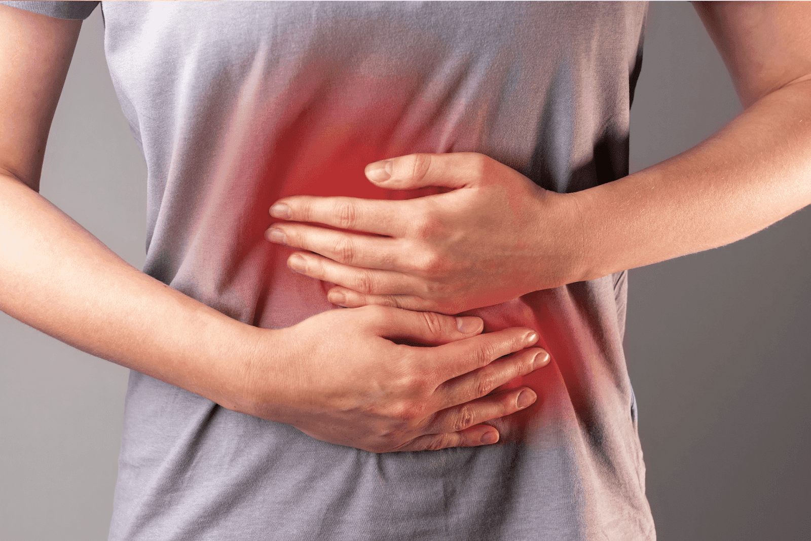 Person holding stomach indicating abdominal pain.