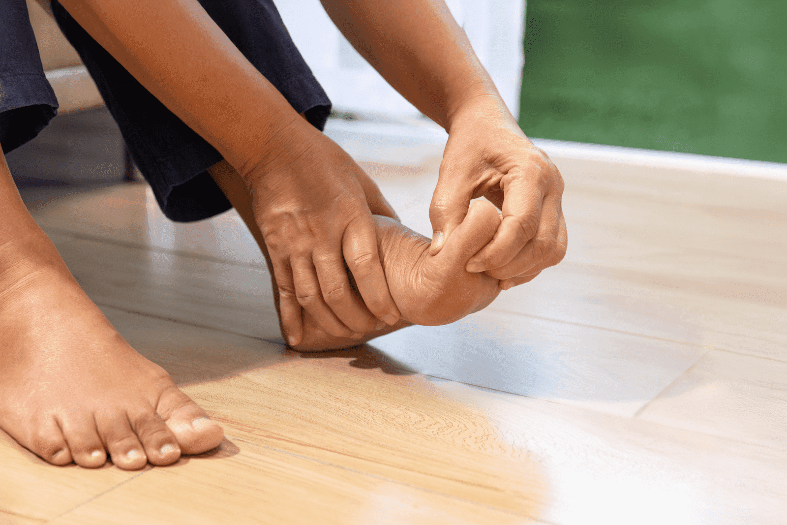 Person holding their big toe while sitting