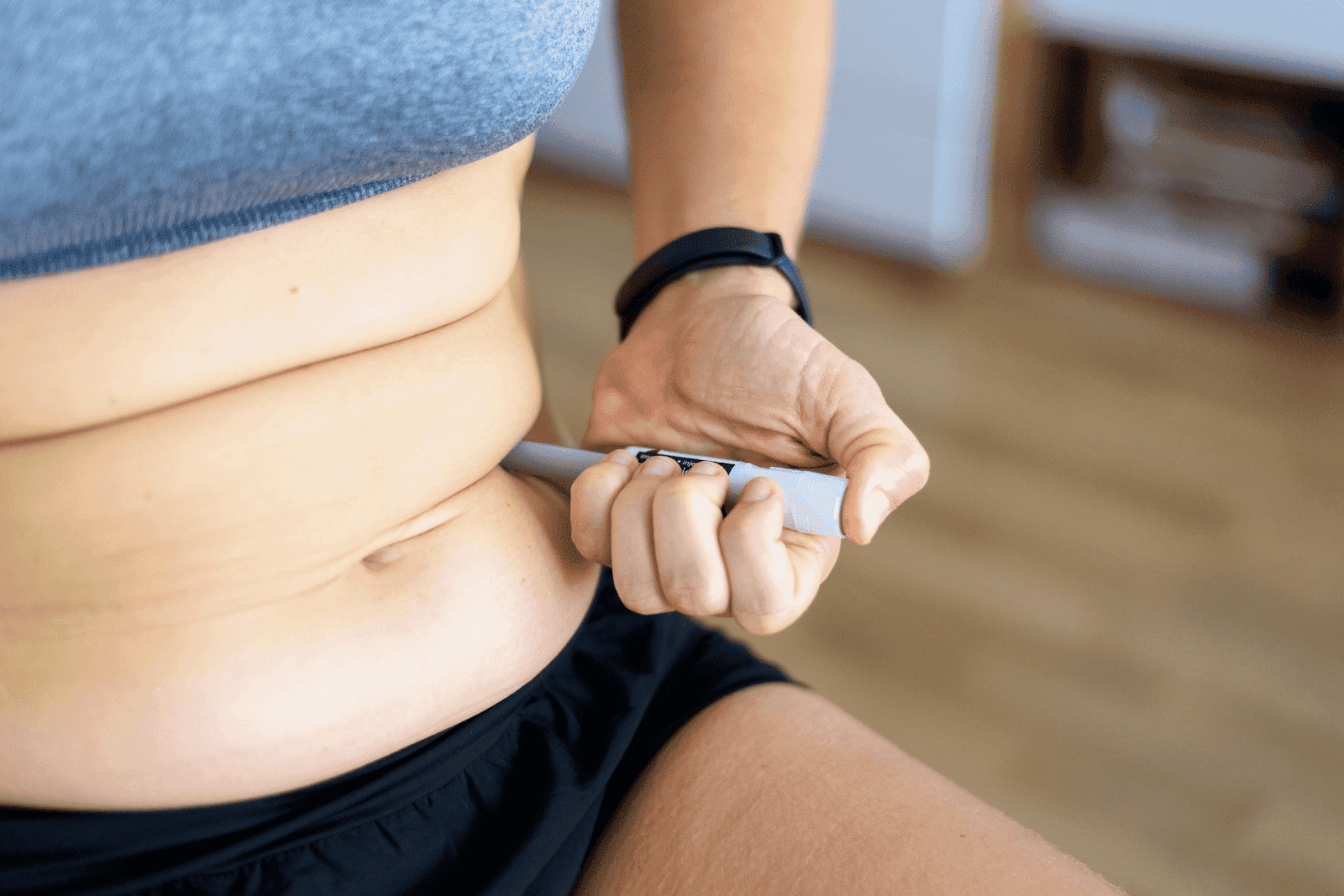 Person injecting medication into their abdomen
