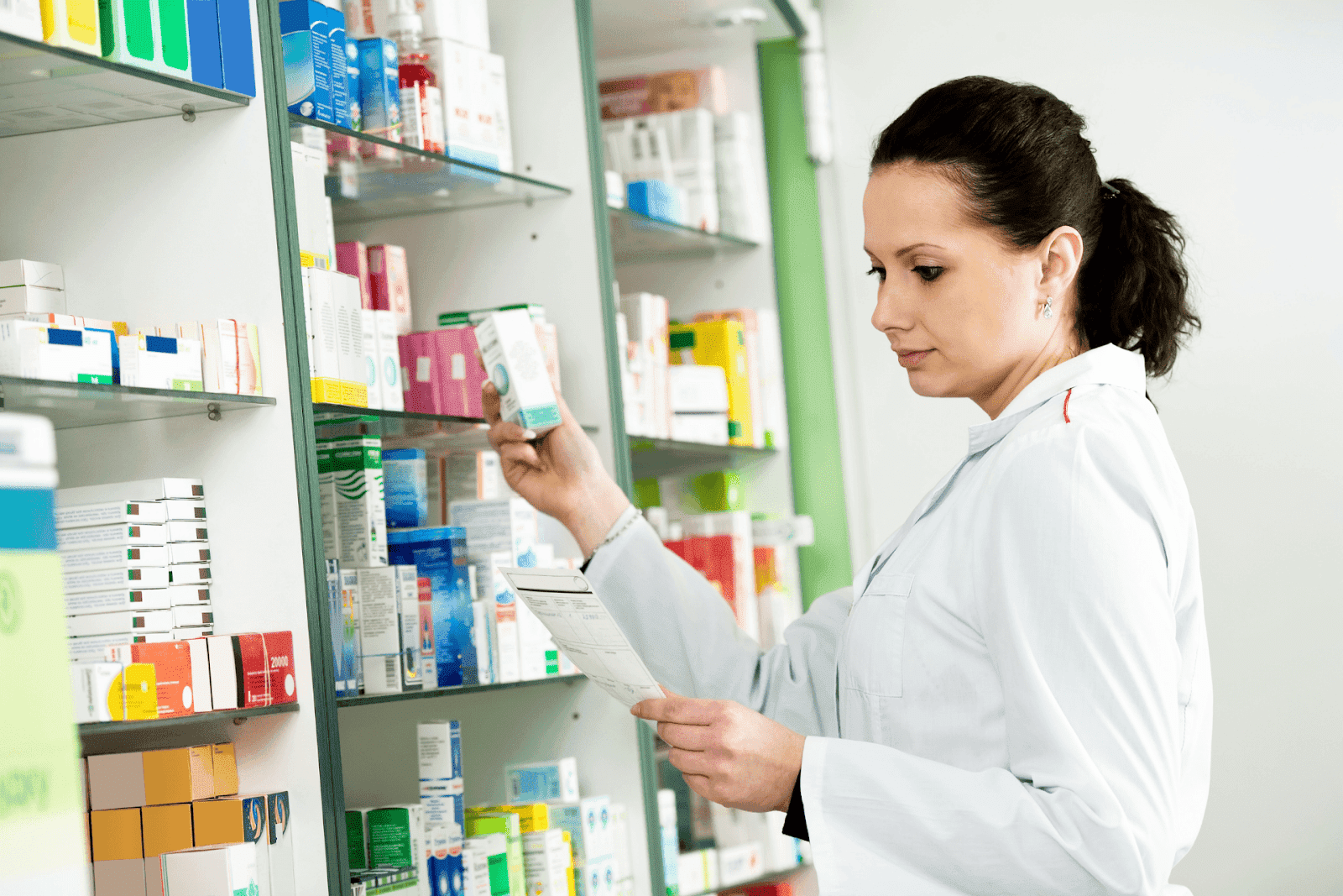 Pharmacist checking medication on a shelf in a pharmacy