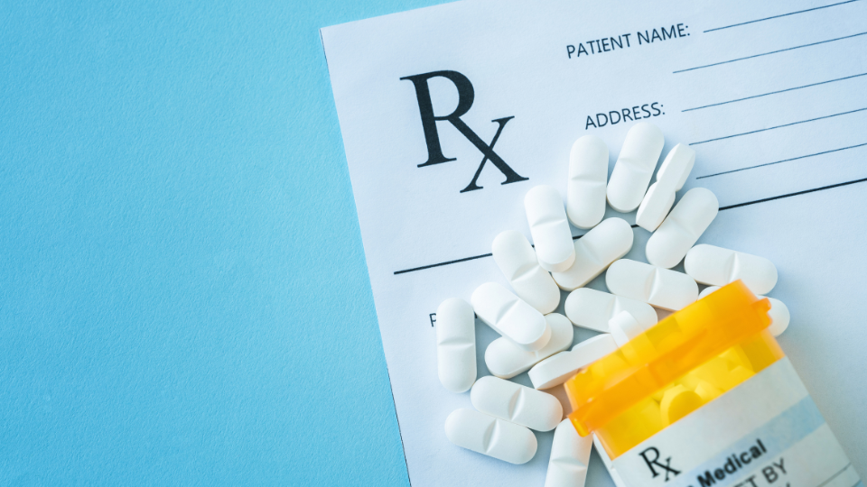 Prescription paper with pills spilled out of canister.