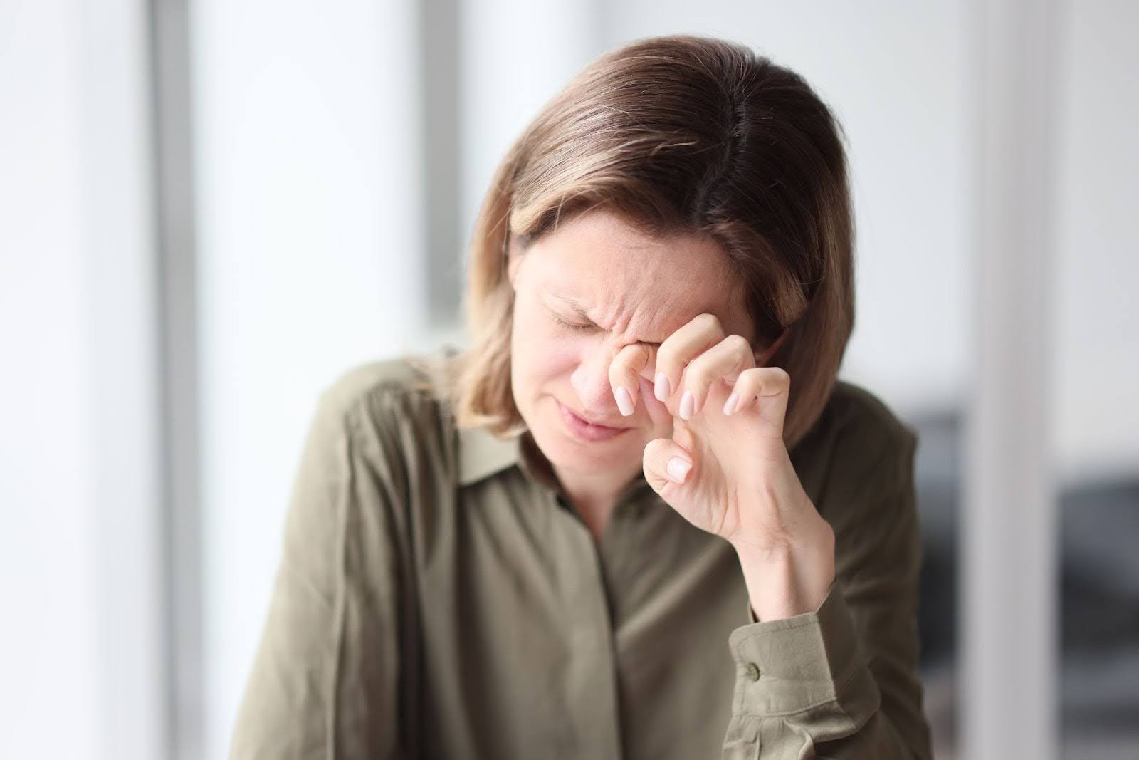 Woman rubbing her eyes in pain