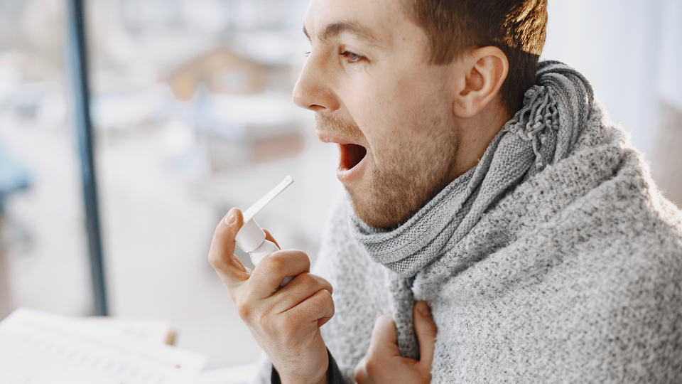 Man spraying throat with treatment for strep