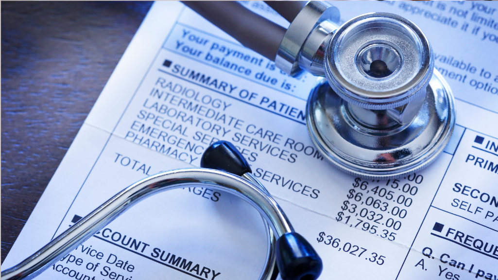 Paper bill showing summary of charges with stethescope on top of paper