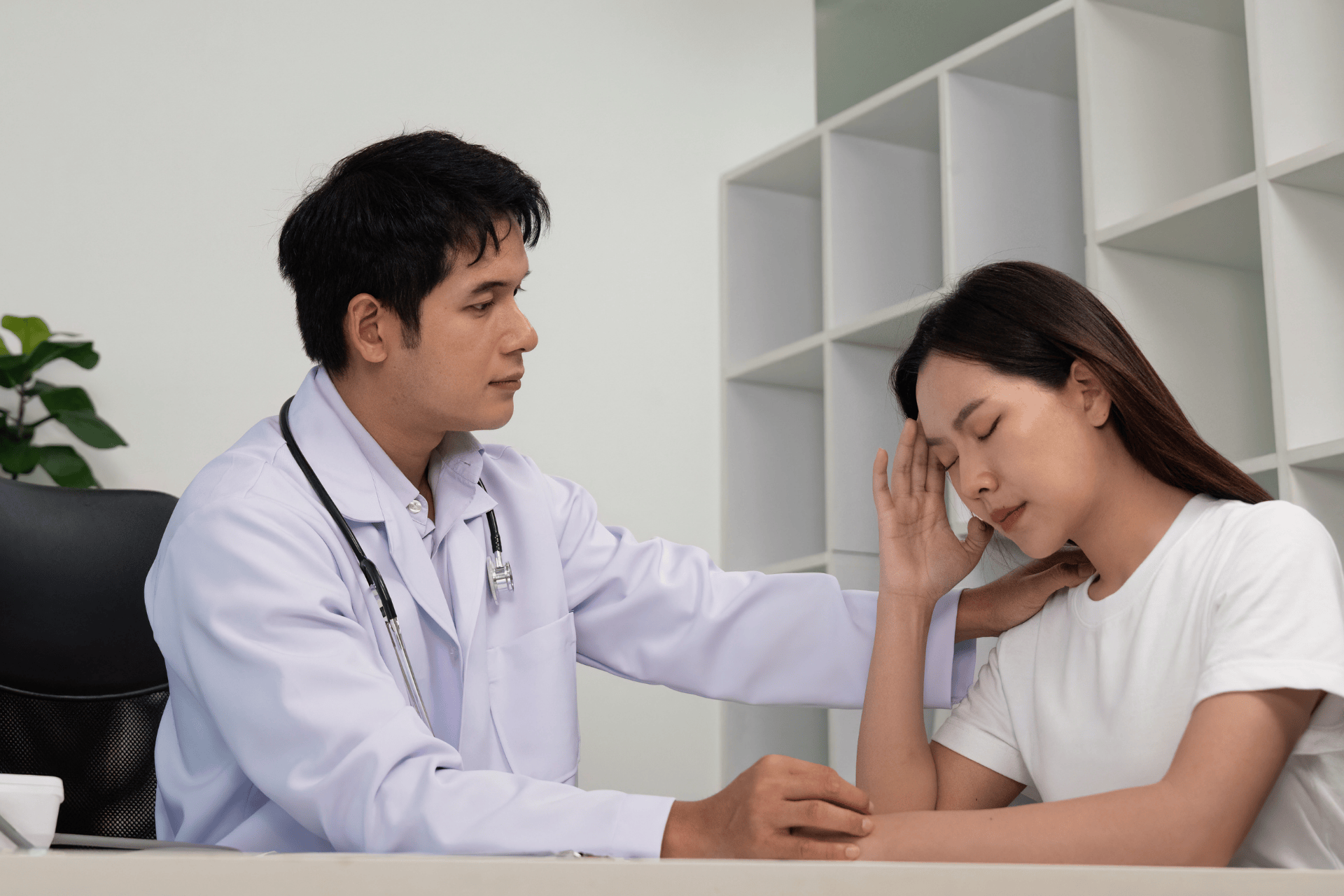 Doctor comforting a patient who appears stressed or unwell during a consultation.