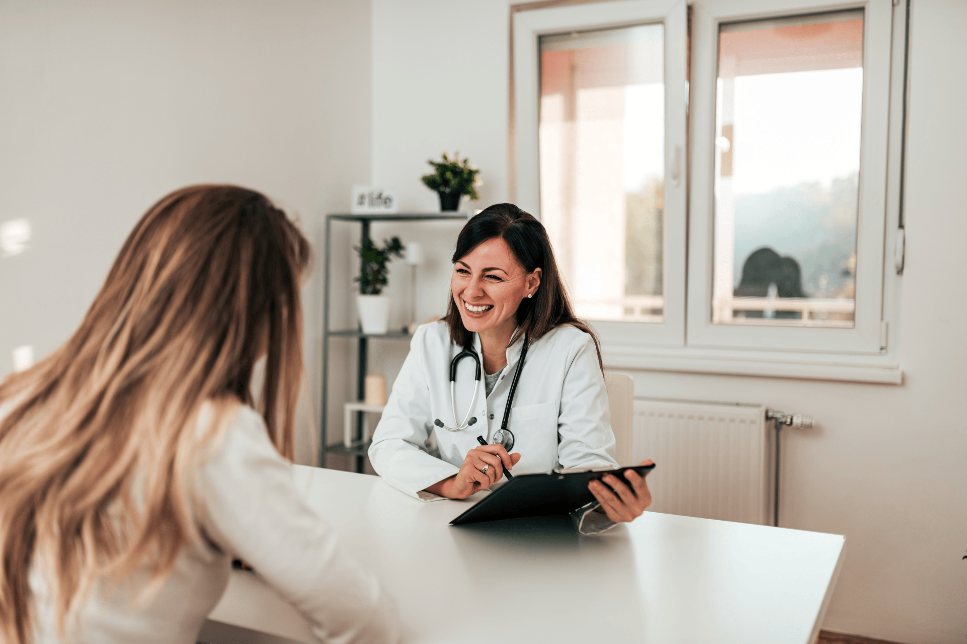 Smiling doctor talking with a patient during a consultation.
