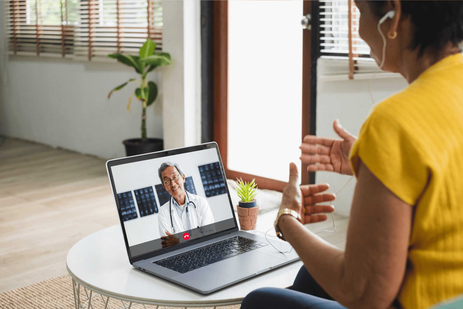 Woman having an online video call with a doctor on her laptop at home.